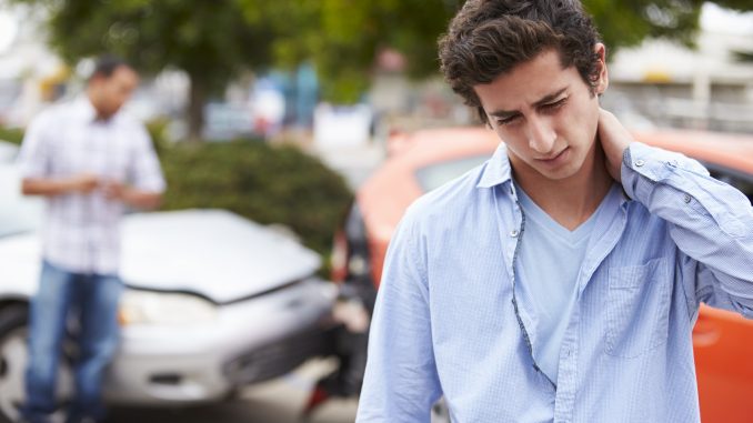 man holds neck after car crash