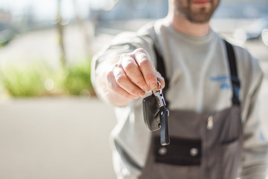 Salesman Handing Over a Car Key to a Buyer